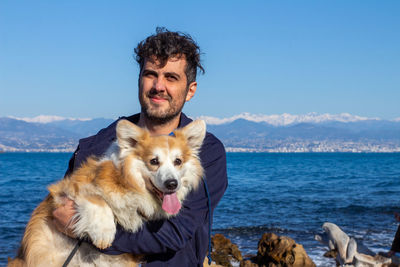 Portrait of man with dog at beach 