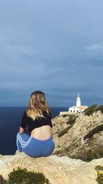 Rear view of woman looking at sea against sky