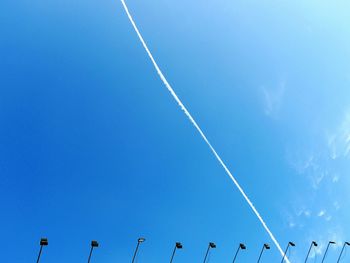 Low angle view of vapor trail against clear blue sky