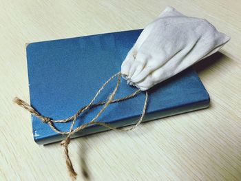 Close-up of pouch with book on wooden table