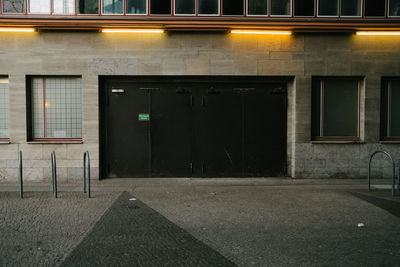 Empty road by building at night