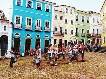 People standing on street against buildings in city