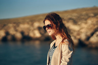 Portrait of woman with sunglasses against water