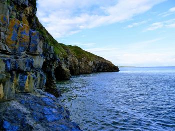 Rock formations by sea against sky