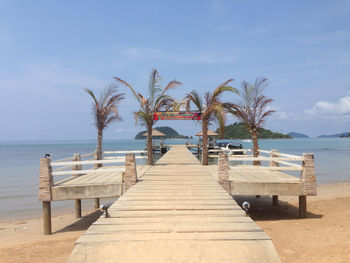 Jetty at beach against sky