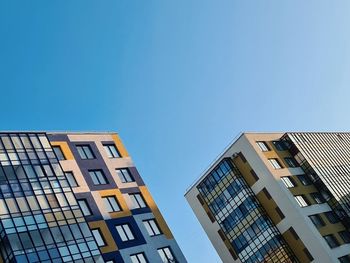 Low angle view of modern building against clear blue sky