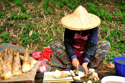 Full length of market vendor cutting food