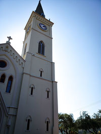 Low angle view of clock tower amidst buildings against sky