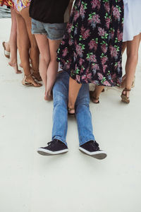 Low section of man lying down amidst women