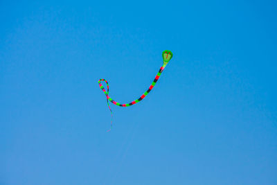 Low angle view of kite against clear blue sky