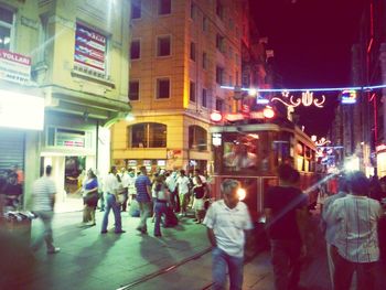 People in illuminated city at night