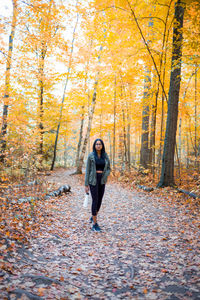 Full length of woman standing in forest during autumn