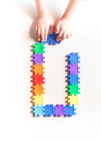Close-up of hand playing with toy against white background