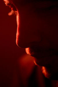 Close-up of depressed man in red lit room