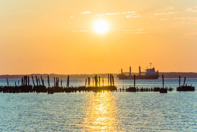 Silhouette of pier on sea during sunset