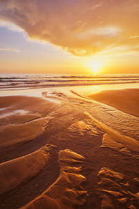 Scenic view of beach against sky during sunset