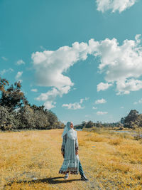 Man standing on field against sky