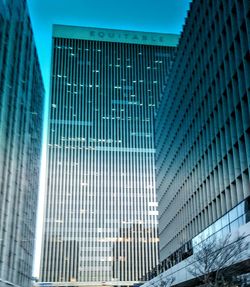 Low angle view of skyscrapers against blue sky