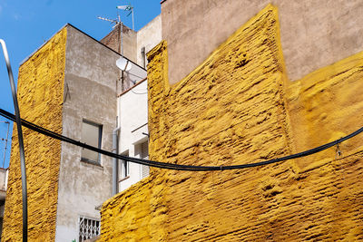 Low angle view of yellow building against sky