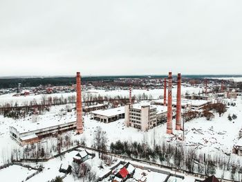 High angle view of snow covered buildings in city against sky