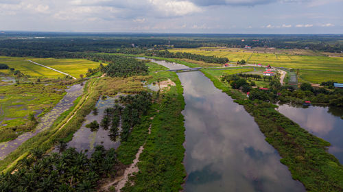 High angle view of river amidst field against sky