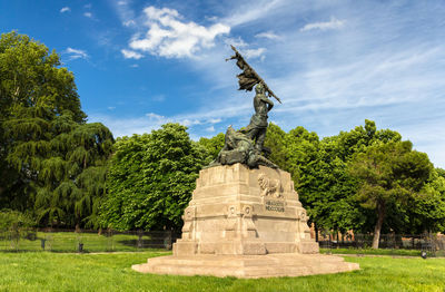 Statue of trees against cloudy sky