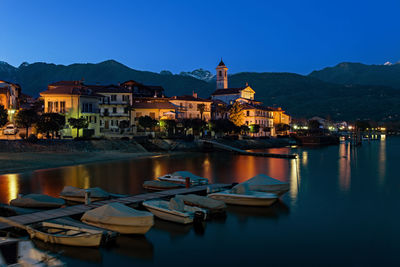 Boats moored in river at night