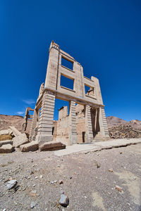 Low angle view of old ruins against clear blue sky