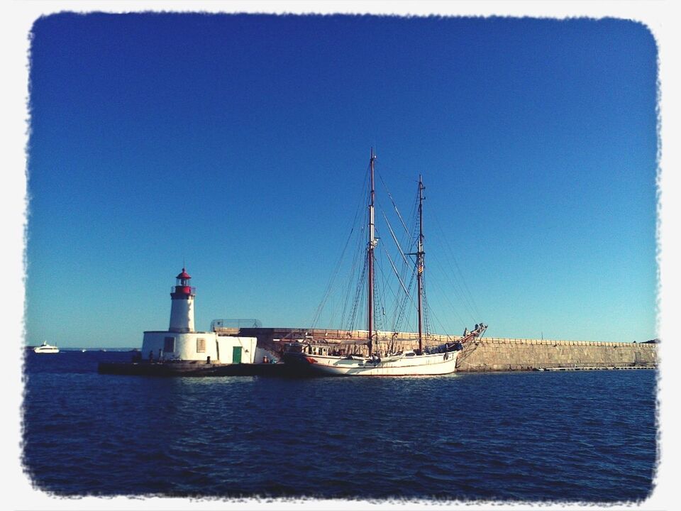 transfer print, water, clear sky, sea, architecture, built structure, building exterior, lighthouse, waterfront, blue, copy space, auto post production filter, nautical vessel, guidance, transportation, boat, day, direction, tower, mode of transport