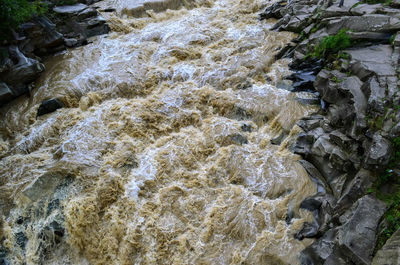 High angle view of stream flowing through rocks