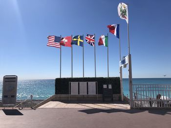 Information sign board by sea against clear sky