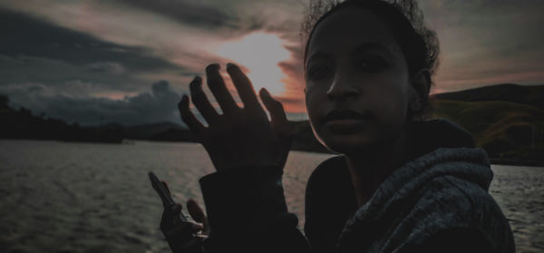 Portrait of man on beach against sky during sunset