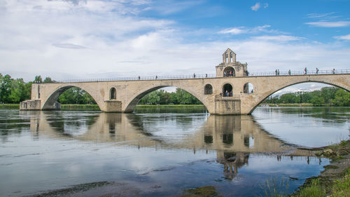 Arch bridge over river against sky