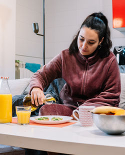 Portrait of young woman preparing food at home