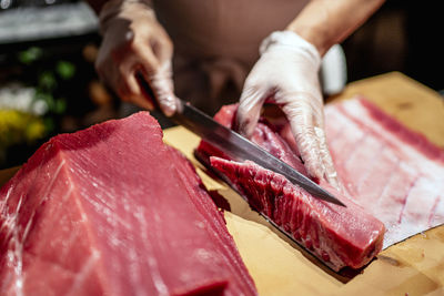 Male chef cutting raw seafood into slices at restaurant