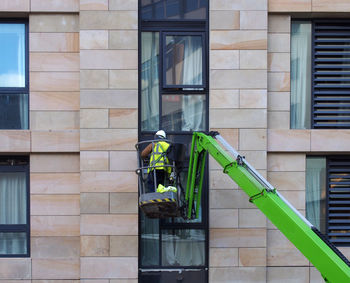 Man working on glass window of building