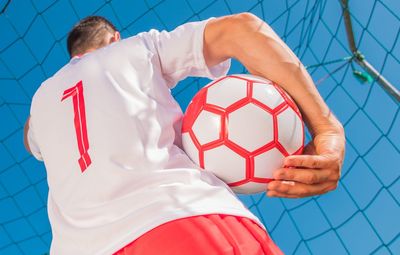 Low angle view of man holding soccer ball