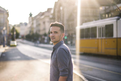 Portrait of young man standing in city