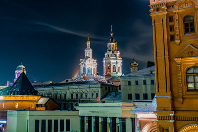 Buildings in city against cloudy sky