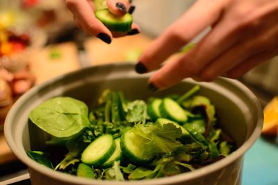 Close-up of hands making salad