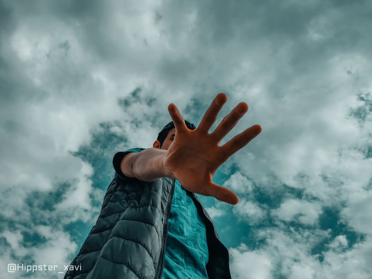 LOW ANGLE VIEW OF HUMAN HAND AGAINST CLOUDY SKY