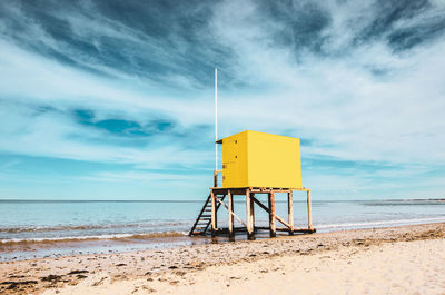 Lifeguard hut on beach against sky