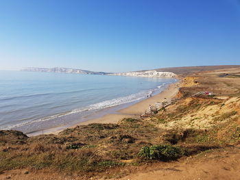 Scenic view of beach against clear blue sky