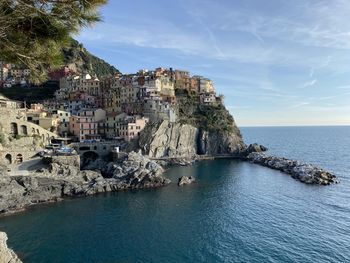 Scenic view of sea by buildings against sky