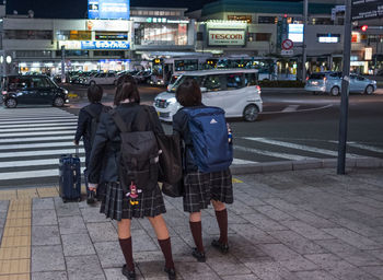 Rear view of people on street at night