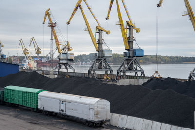 Loading coal anthracite into the railway freight wagons in port with crane bucket