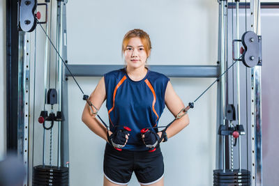 Portrait of young woman exercising in gym