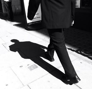 Low section of man standing on tiled floor