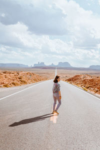 Full length of woman on road against sky