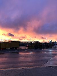 Road in city against sky during sunset